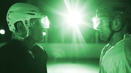 Kaksi jääkiekkoilijaa seisoo ja tuijottaa toisiaan.